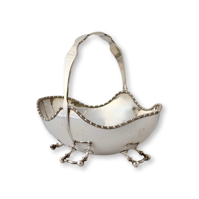 This elegant silver-plate basket showcases design hallmarks attributed to Christopher Dresser, a pioneer of modern design....