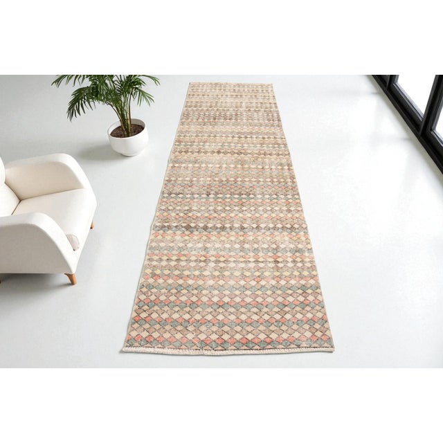 This is a vintage Turkish Oushak rug from the Mid 20th Century. The piece was hand-knotted.