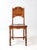 This vintage oak chair from the early to mid-20th century features classic turned legs and a hand-stenciled design on the...