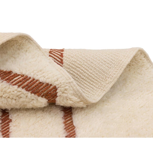 Exquisite hand-knotted wool rug with handwoven geometric patterns in Cinnamon Stick on an Ivory backdrop, perfect for...