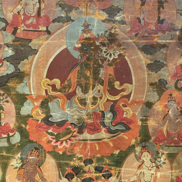 An incredible and rare 18th century Tibetan Thangka depicting the Green Tara seated on a lotus throne with her right hand...
