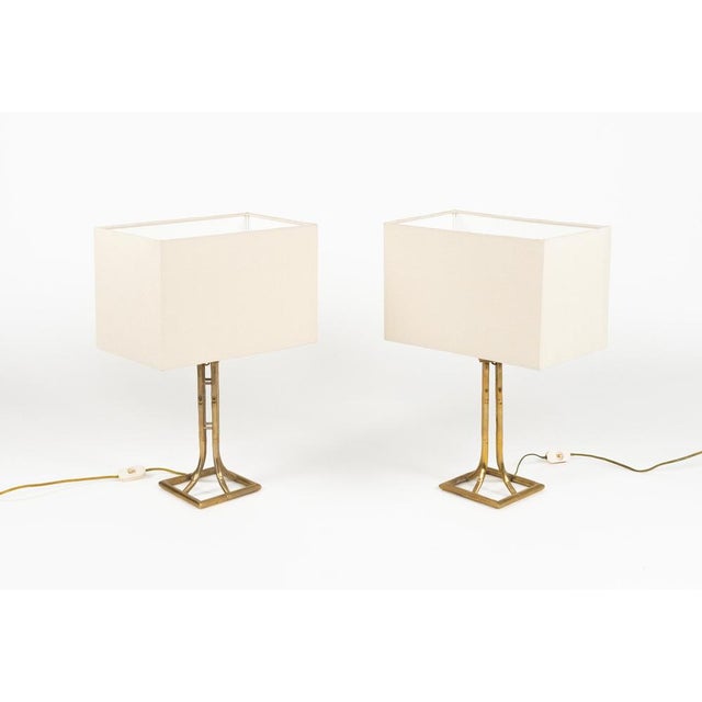 Midcentury amazing pair of table lamps in brass faux bamboo and fabric lampshade in the style of Maison Baguès. Made in...