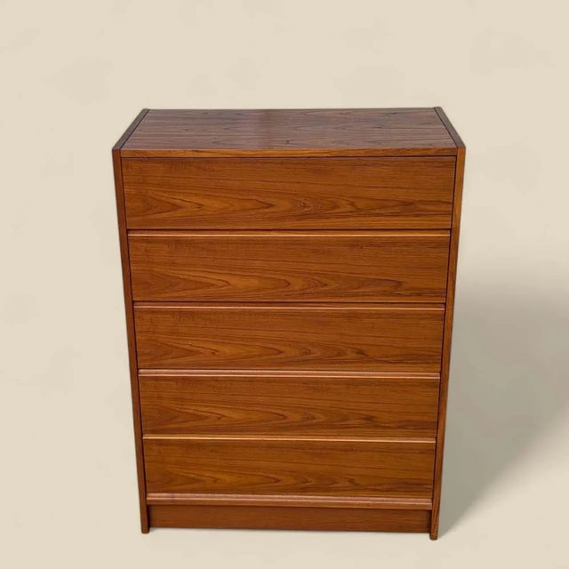 A tall and elegantly proportioned Danish teak dresser from the 1960s, offering five drawers within a compact footprint....