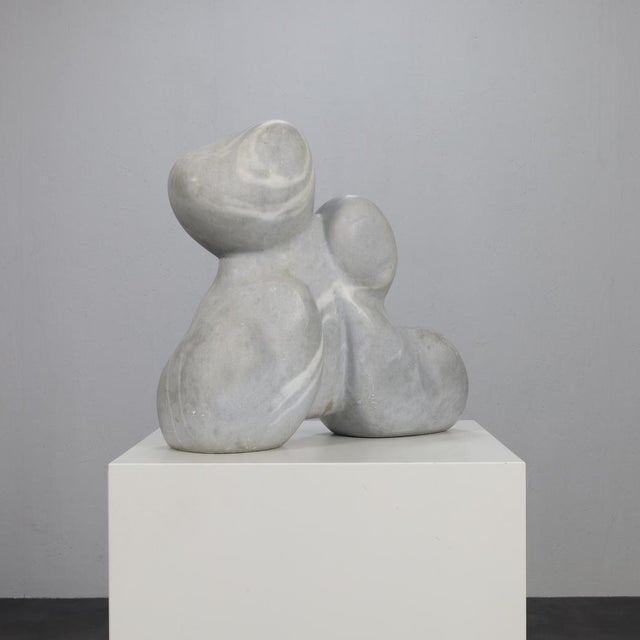 Titled “Mother and Child”, this serene marble sculpture by Mario Orsogna evokes intimacy through abstraction. Its rounded,...