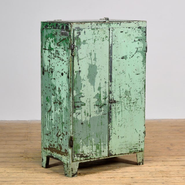 Industrial cabinet from the 1970s, made of iron. This robust eye-catcher has a practical top flap and offers a surprising...
