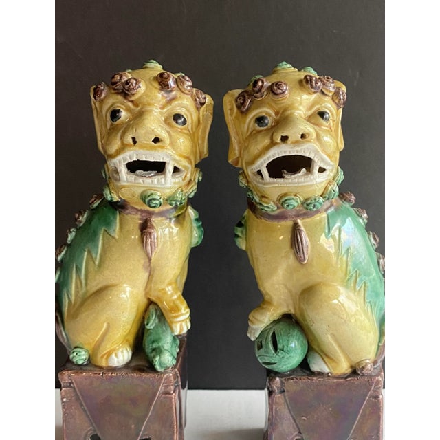 Pair of antique 8.5” multi-colored Chinese ceramic guardian lions or foo dogs, circa early 20th century. This set of...