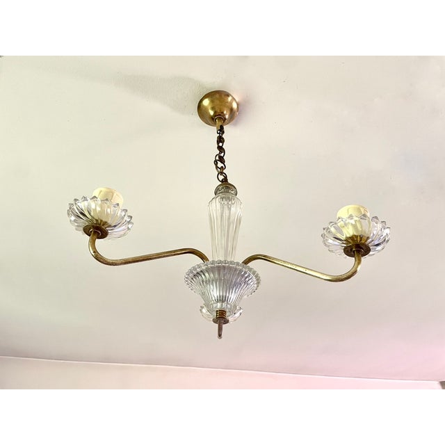 Three-arm chandelier from the 1950s gilt brass frame and textured glass suspended by a small chain light and delicate...