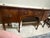 English George III mahogany sideboard ca.1780 plus later additions. The bow-front top with double stringing creates a...