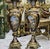 Elegant black porcelain vase featuring rich gold leaf detailing and central cherub angel sky scenes, creating a striking...