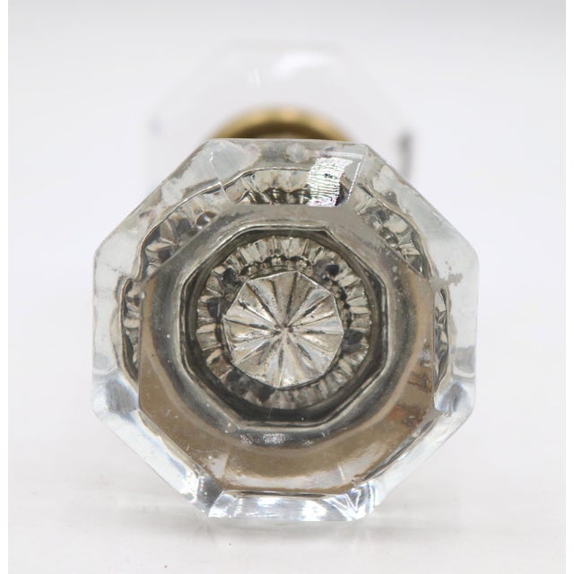 Antique octagon clear glass door knobs with a bullet center design. The rosettes are made of polished brass. Priced as two...