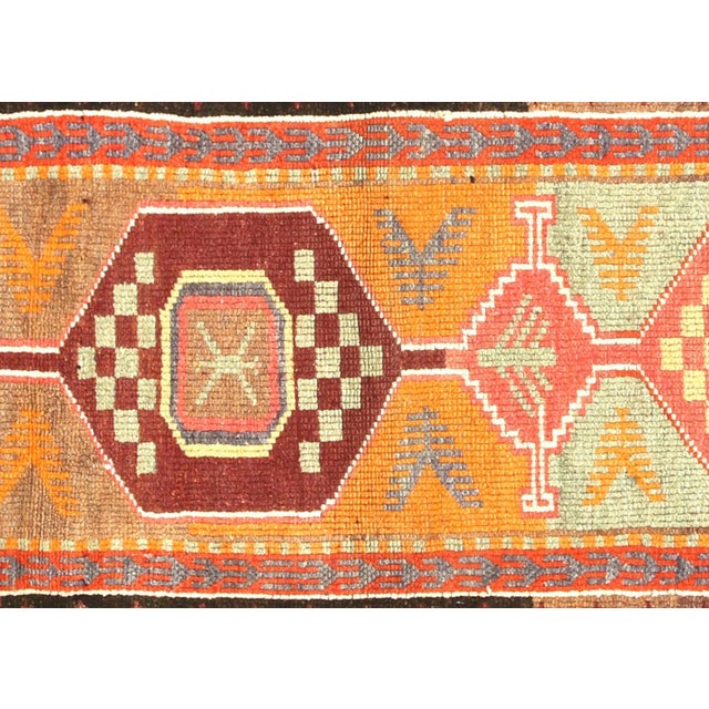 This vintage Turkish Oushak runner, measuring 2'7" x 10', is handwoven with wool on a wool foundation in Western Turkey's...