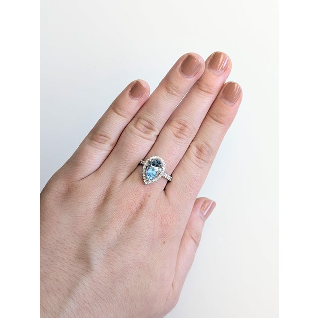 A rare santa maria aquamarine shines in a deep sea-blue at the heart of this solid 14K white gold ring, framed by thirteen...