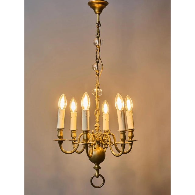 An antique six-arm bronze chandelier from the 19th century is an elegant example of historical interior lighting,...