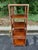 A classic Baker Furniture campaign-style étagère crafted in rich mahogany with solid brass corner accents and hardware....
