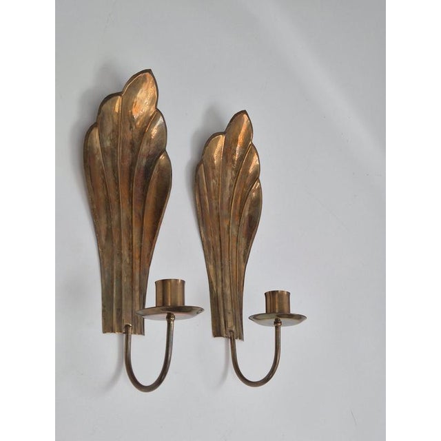 A paif of classic shell shaped candle sconces in solid brass by Lars Holmström, Arvika, Swedish Modern 1940s. A simple...