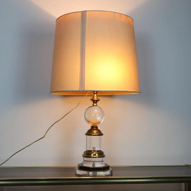 Wonderful and scenic table lamp made around 1970s in Italy. Hollywood Regency key frame in Acrylic and Brass. Its base...