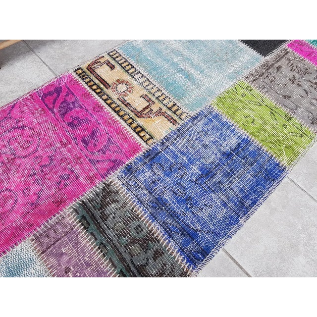 This is a vintage Turkish Oushak rug from the Mid 20th Century. The piece was hand-knotted.