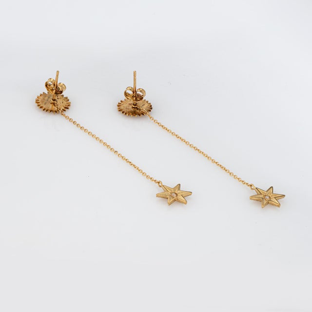 Finely detailed pair of pre-owned Anthony Lent Sunface star drop earrings crafted in 18k yellow gold. From the celestial...