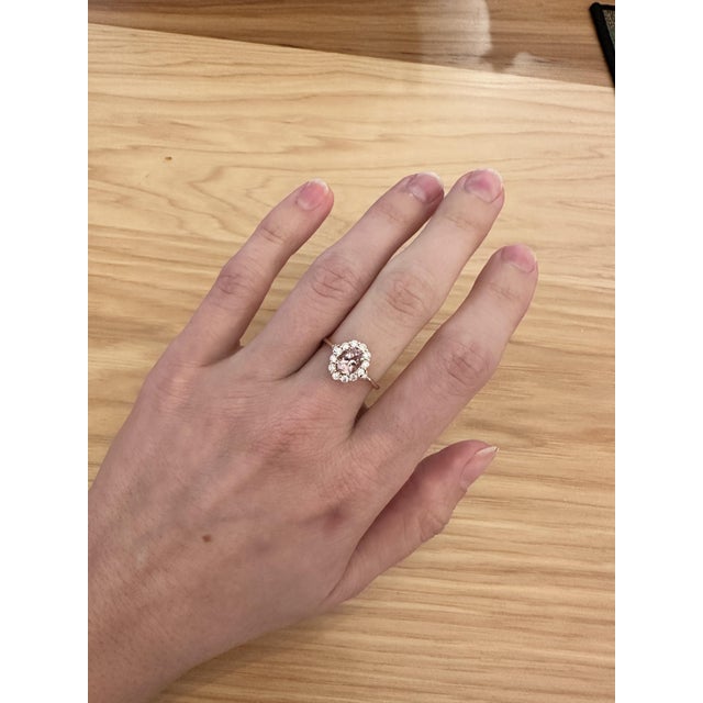 This beautiful ring features a pretty 0.67 carat pink morganite gemstone with a halo of natural earth-mined diamonds and a...