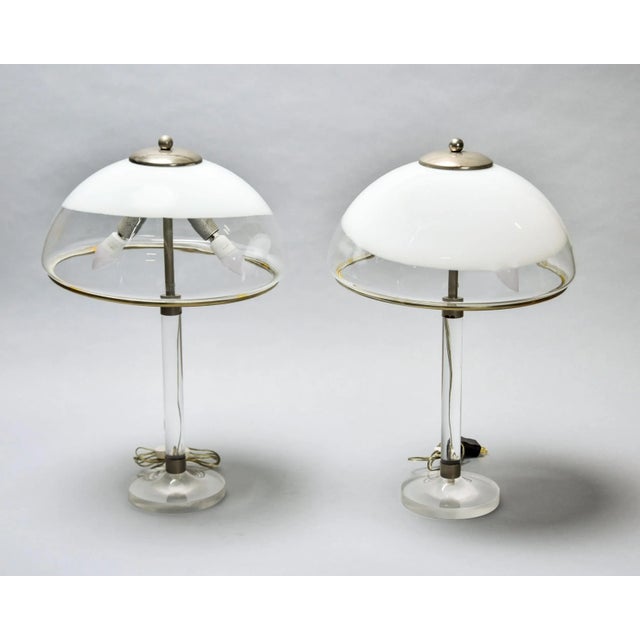 Found in Italy, this unusual pair of table lamps date from the 1970s. Each lamp features a clear Lucite base and support...
