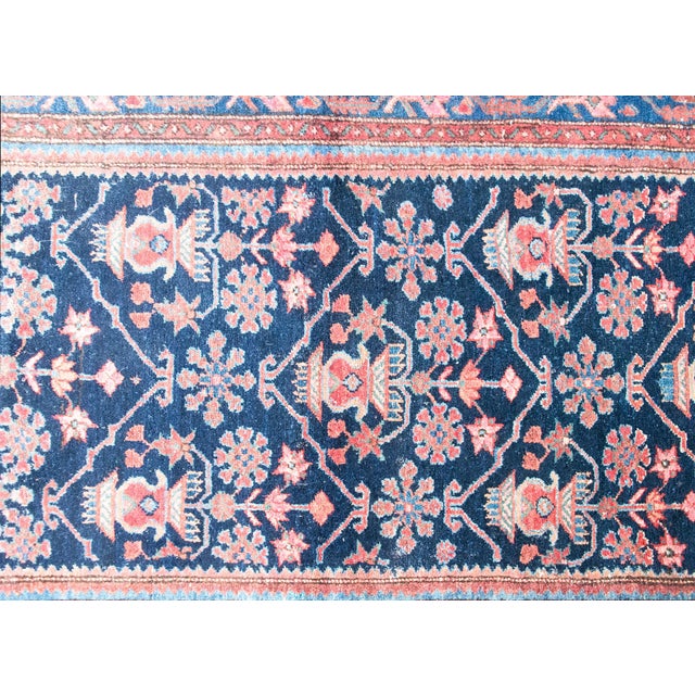 A finely woven Persian Malayer rug from the early 20th century, featuring a rich navy field filled with floral sprays and...