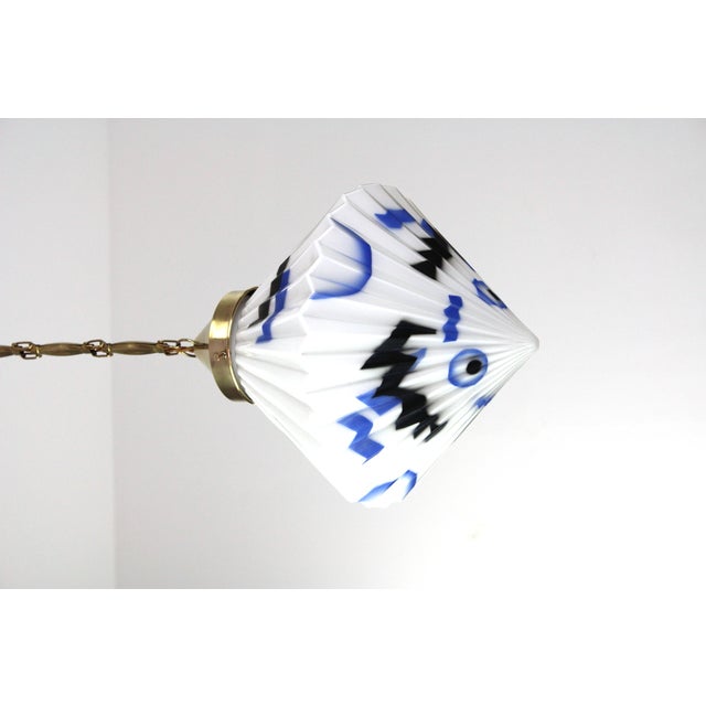 White opal glass in pleated shape, sprayed decoration, brass suspension, glass 30x30cm, total height with chain 110cm, an...