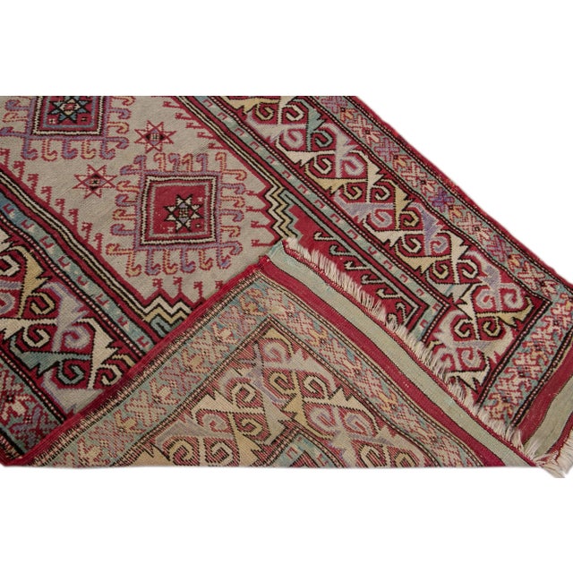 Beautiful Sivas hand-knotted wool rug with a beige field. This piece has red borders and a multicolor accents layout on a...