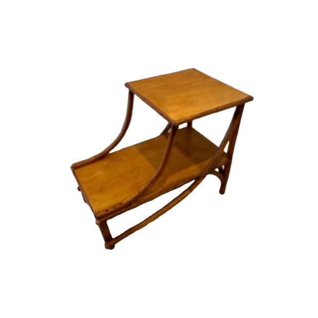 A charming vintage two-tier side table dating to the 1960s, featuring a combination of natural rattan and bamboo in the...