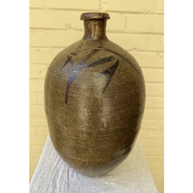 Discover the charm of this Vintage Large Japanese Handmade Stoneware Sake Bottle, a perfect blend of artistry and utility....