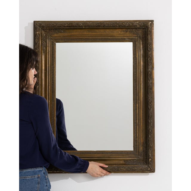 A 19th century French wall mirror designed in the Empire style, characterized by a structured and symmetrical frame. The...