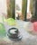 Compelling by Mia Bergeron | Oil on Panel Still life of a cake and colorful balloons near a window For Sale