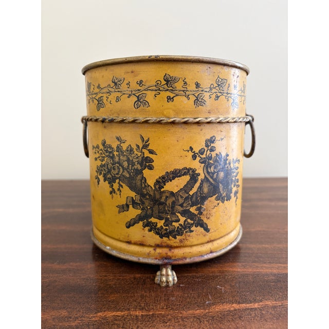 A gorgeous neoclassical yellow tole cachepot, planter, or vase with hand-painted details and brass lion paw feet Italy,...