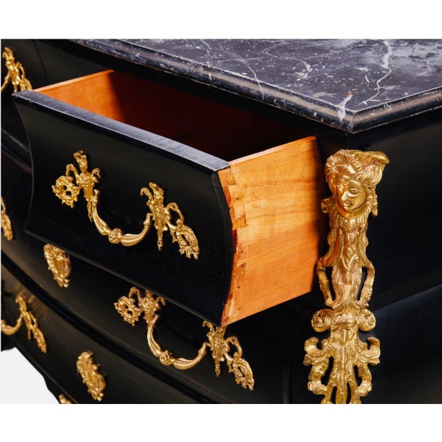 19th Century French Louis XV Ebonized Gilt-Bronze Mounted Bombé Marble-Top Chest A dramatic late 19th-century French Louis...