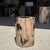Small side table made of petrified wood with a black heartwood and black and beige striped bark. Petrified wood is a...