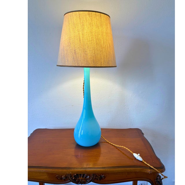Elegant Mid-Century Murano glass table lamp, crafted in Italy in the 1960s. The lamp features a striking hand-blown Murano...