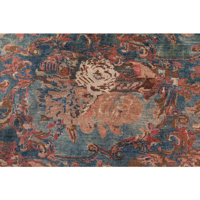 An early 20th century Persian Tabriz oriental rugs, the blue field with rows of staggered blossom bouquets framed by a...
