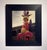 This artwork presents a striking figure adorned in flamboyant attire, including a pink tutu and a whimsical ship perched...
