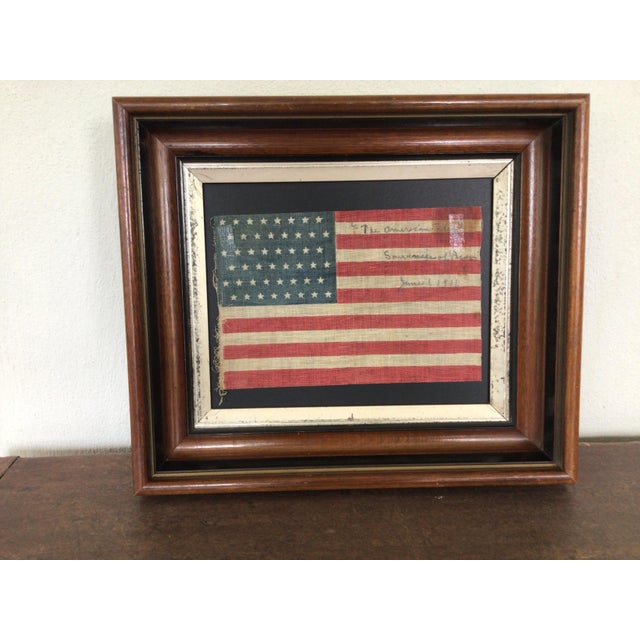 A small parade flag on coarse cotton with an ink inscription on the top white stripes. The stars are arranged in 6...