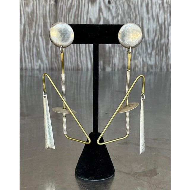 These Vintage Abstract Mixed Metal Dangle Earrings are a striking blend of artistic expression and timeless style. Crafted...