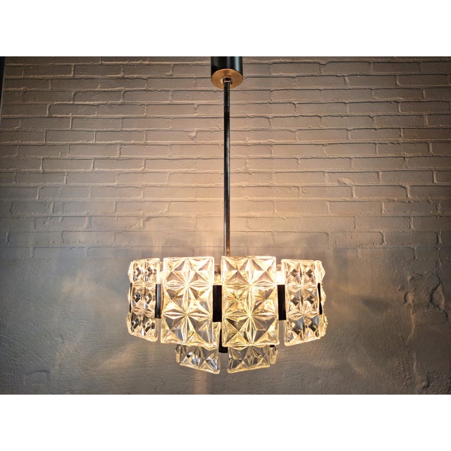 Beautiful 2-layered mid-century chandelier made of patinated metal and crystal glass by hillebrand. The chandelier has 6x...