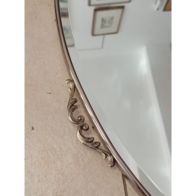 Vintage wall mirror Silver anodized brass with friezes Made in Italy, 1970s, with sticker on the back Oval shape, with...