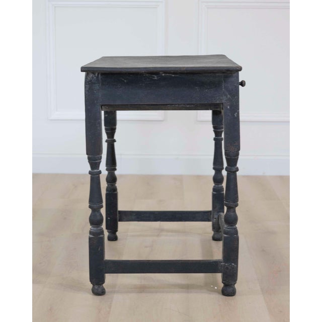 Made in England around 1780, this painted oak side table has a single drawer. Oak was a traditional English furniture...