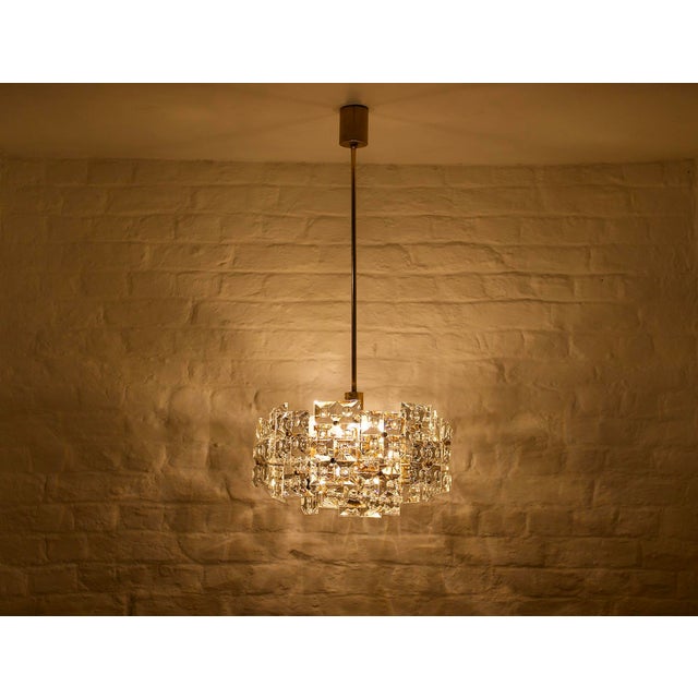 Gold-plated brass chandelier, fitted with 30 thick crystal pendants, deeply cut in an "optical" grid pattern. Manufactured...