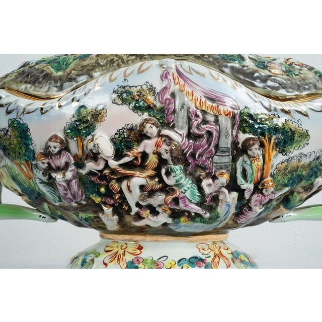 An antique polychrome Capodimonte porcelain soup tureen dating from the mid-20th century. The bowl has a rounded shape,...