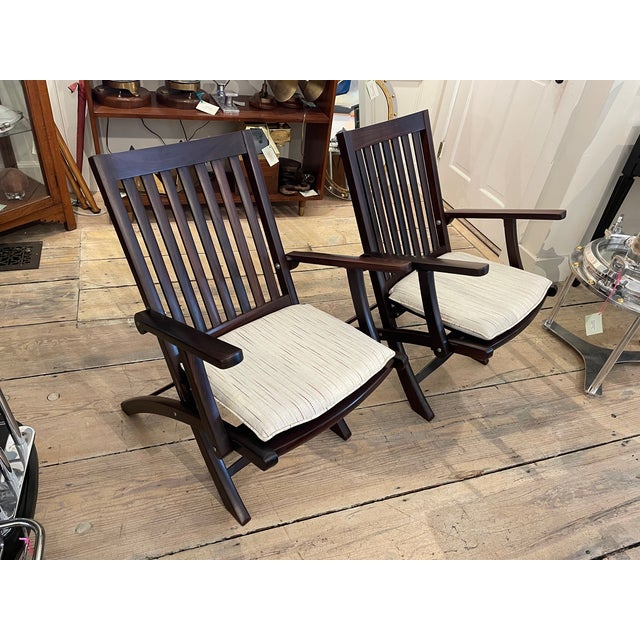 A pair of simple and elegant folding rosewood steamer chairs used by the British in the early 1900's on ships, on safaris,...