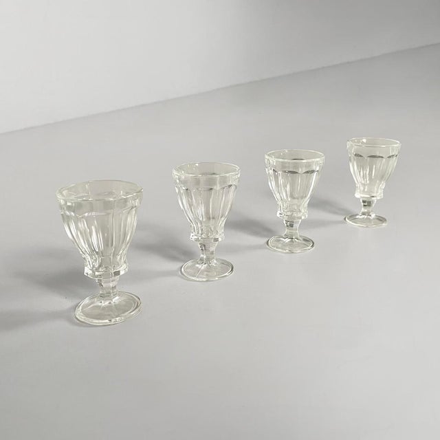 Italian Art Deco small glass glasses, 1930s Set of four glasses in thick, clear, worked glass. The glass has a classic...