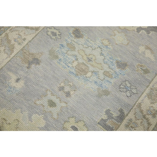 This modern Turkish Oushak rug is a stunning piece of art that has been handwoven using traditional techniques by skilled...
