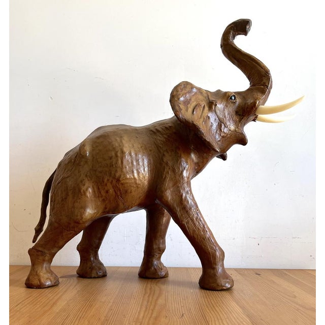 Elephant produced in the 1960s/1970s in brown leather with details of leather folds and glass eyes with slight signs of...