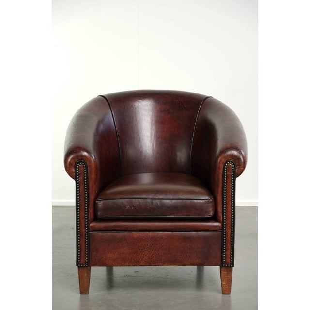 This rugged vintage sheepskin club chair features beautiful brown and red tones and has a luxurious finish with decorative...