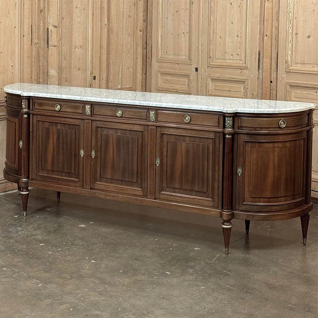 Grand French Louis XVI Mahogany Round-Sided Buffet with Carrara Marble is a magnificent example of the classical revival...